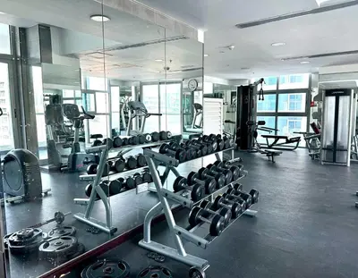 a gym with a lot of equipment in a room at Cozy Studio at DEC Tower in Dubai