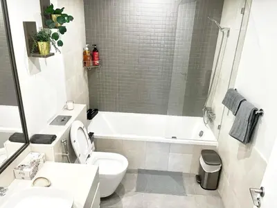 a bathroom with a toilet and a tub and a sink at Luxury 1 Bed in the heart of the city! Free WiFi in Dubai