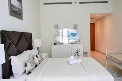 a bedroom with a large white bed with a mirror at Nivis find-Affordable & Spacious 1 BHK- 10 Mins to Dubai Mall in Dubai