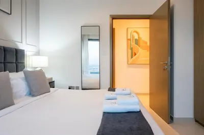 a bedroom with a large white bed and a door at 2BR Boutique Apartments at Burj Royale - Burj Khalifa & Dubai Mall in Dubai