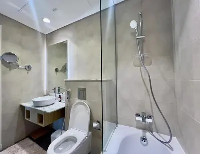 a bathroom with a shower and a toilet and a sink at Exclusive 1BR with Iconic Views in Paramount Tower in Dubai