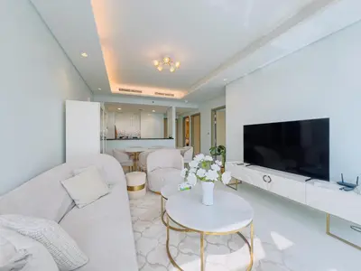 a living room with a white couch and a tv at Exclusive 1BR with Iconic Views in Paramount Tower in Dubai