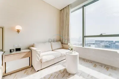 a living room with a white couch and a large window at High-Rise Studio Overlooking the Sea with a Glimpse of Ain Dubai, The Palm Tower, Palm Jumeirah by Deluxe Holiday Homes in Dubai