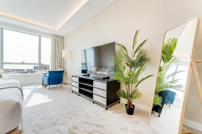 a bedroom with a bed and a mirror and a plant at High-Rise Studio Overlooking the Sea with a Glimpse of Ain Dubai, The Palm Tower, Palm Jumeirah by Deluxe Holiday Homes in Dubai