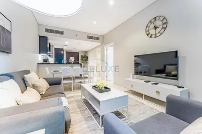 a living room with a couch and a tv at Pool and City View 1BR Near Dubai Water Canal, The Cosmopolitan, Business Bay by Deluxe Holiday Homes in Dubai