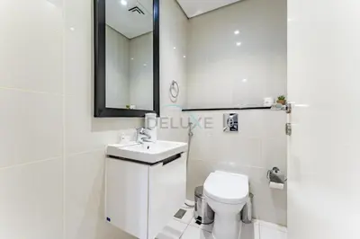 a bathroom with a toilet and a sink and a mirror at Pool and City View 1BR Near Dubai Water Canal, The Cosmopolitan, Business Bay by Deluxe Holiday Homes in Dubai