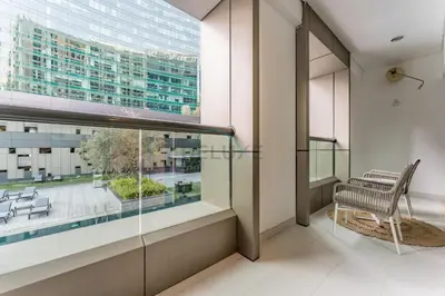 a balcony with a chair and a large window at Pool and City View 1BR Near Dubai Water Canal, The Cosmopolitan, Business Bay by Deluxe Holiday Homes in Dubai