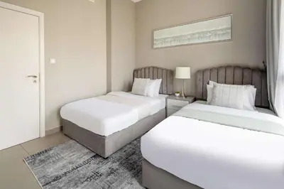 two beds in a hotel room with white sheets at Frank Porter - Hayat Boulevard 2B in Dubai