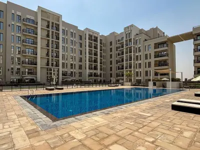 a swimming pool in front of a large apartment building at Frank Porter - Hayat Boulevard 2B in Dubai