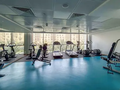 a gym with several treadmills and exercise bikes at Frank Porter - Hayat Boulevard 2B in Dubai