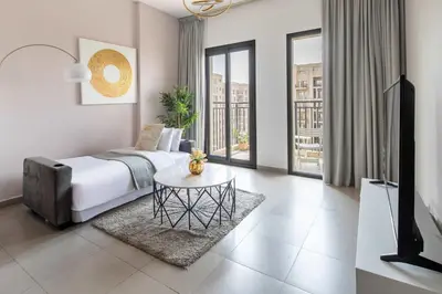 a bedroom with a bed and a table in a room at Frank Porter - Hayat Boulevard 2B in Dubai