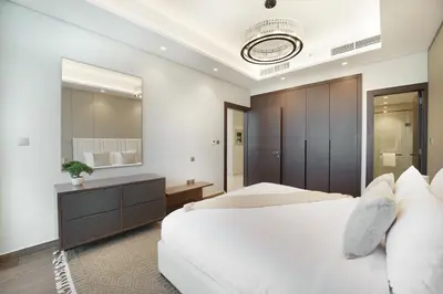 a bedroom with a white bed and a large mirror at EasyGo- Luxury 1BR with Burj Khalifa view and lavish Amenities in Dubai