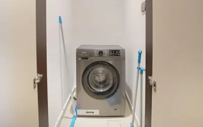 a washing machine in a laundry room with two toothbrushes at EasyGo- Luxury 1BR with Burj Khalifa view and lavish Amenities in Dubai