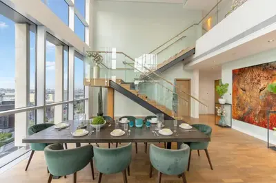 a dining room with a wooden table and green chairs at FAM Living -Duplex 4Bed and Maids in Dubai