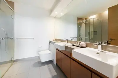 a bathroom with two sinks and a toilet and a shower at FAM Living -Duplex 4Bed and Maids in Dubai