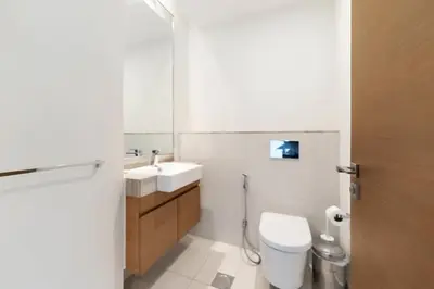 a bathroom with a sink and a toilet and a mirror at FAM Living -Duplex 4Bed and Maids in Dubai