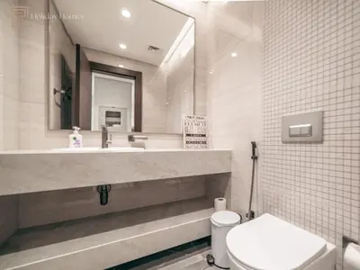 a bathroom with a sink and a toilet and a mirror at Modern 1-Bed Apartment in a Prime Central Location in Dubai