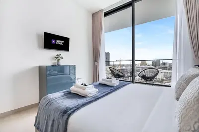 a hotel room with a bed and a large window at Exceptional 1BR flat wBalcony Gym & Pool in JVC in Dubai