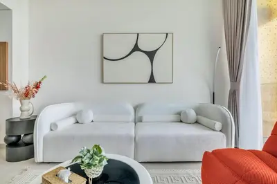 a living room with a couch and a table at Exceptional 1BR flat wBalcony Gym & Pool in JVC in Dubai