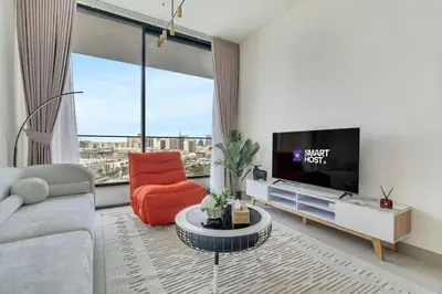 a living room with a couch and a tv at Exceptional 1BR flat wBalcony Gym & Pool in JVC in Dubai