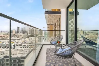 a balcony with two chairs and a view of a city at Exceptional 1BR flat wBalcony Gym & Pool in JVC in Dubai