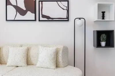a living room with a white couch with pictures on the wall at Contemporary 2 Bedroom Apartment in Dubai