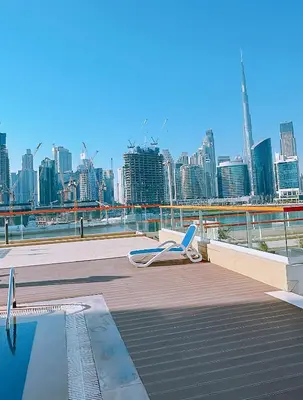 a chair sitting on a deck with a view of a city at Luxury Oasis - Burj Khalifa Views in Dubai