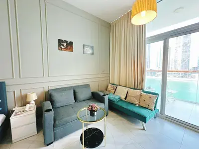 a living room with a blue couch and a table at Luxury Oasis - Burj Khalifa Views in Dubai
