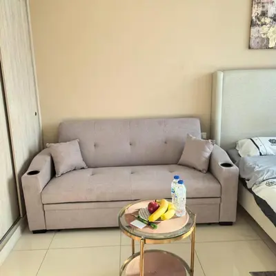 a living room with a couch and a table with fruit on it at Seven Palm west beach Studio in Dubai