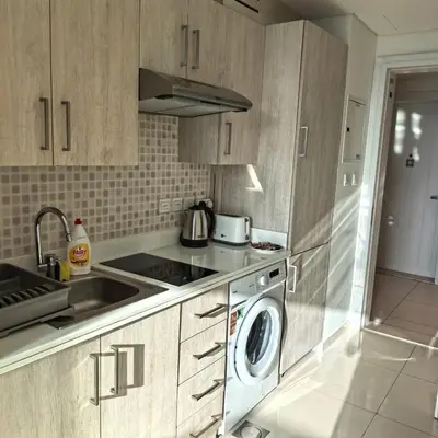 a kitchen with a sink and a washing machine at Seven Palm west beach Studio in Dubai