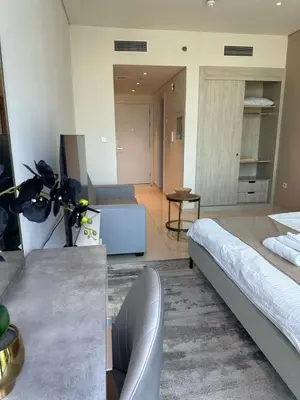 a bedroom with two beds and a living room at Seven Palm west beach Studio in Dubai