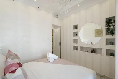 a white bedroom with a bed and a mirror at High Floor Upgraded 2BR in JLT - Walk to Lake Park in Dubai