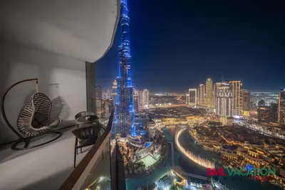 a view of a city skyline at night at SML Vacation Homes - Sky High Apartments with Burj Khalifa and Dubai Fountain Views at Grande Signature, Downtown Dubai in Dubai