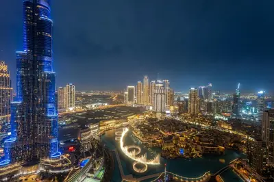 a view of a city at night at SML Vacation Homes - Sky High Apartments with Burj Khalifa and Dubai Fountain Views at Grande Signature, Downtown Dubai in Dubai