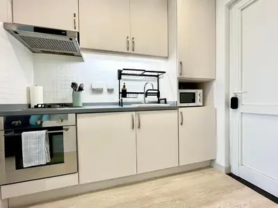a kitchen with white cabinets and a sink at Upgraded & Cozy Boutique Studio in Palm Jumeirah PV7 in Dubai