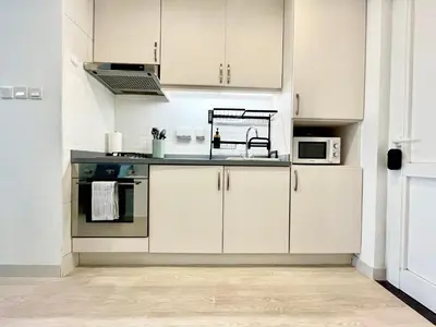 a kitchen with white cabinets and a sink at Upgraded & Cozy Boutique Studio in Palm Jumeirah PV7 in Dubai