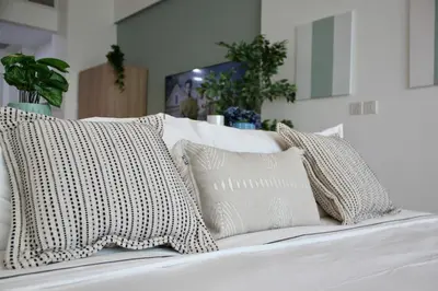 a white bed with four pillows on it at Upgraded & Cozy Boutique Studio in Palm Jumeirah PV7 in Dubai