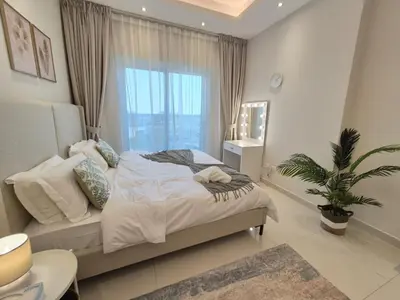 a bedroom with a bed and a large window at Studio in Hera towers, Dubai sports city in Dubai