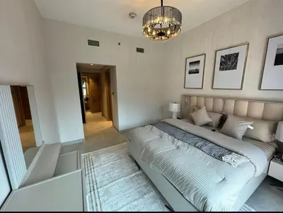 a bedroom with a large bed and a chandelier at 1 bedroom apartment in Jumeirah in Dubai