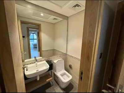 a bathroom with a sink and a toilet and a mirror at 1 bedroom apartment in Jumeirah in Dubai