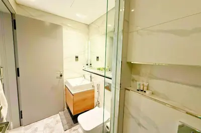 a bathroom with a sink and a toilet and a mirror at Top Floor Studio with Sofa Bed Walk to Dubai Mall by Vibel in Dubai