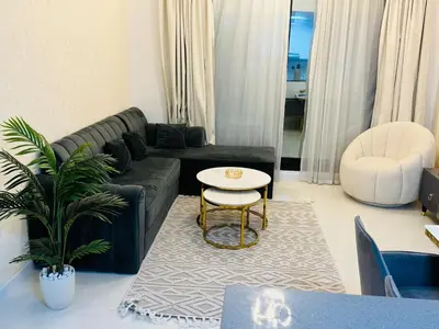 a living room with a black couch and a table at 1BHK LUXURY PRIVATE APARTMENT - Dubai Marina - 2 MIN WALK FROM TRAM in Dubai