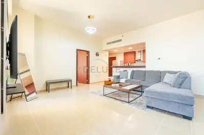 a living room with a blue couch and a table at Sea-Facing 1BR with Ain Dubai View Close to Marina Beach, Rimal 3, Jumeirah Beach Residence by Deluxe Holiday Homes in Dubai