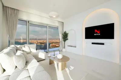 a living room with a white couch and a tv at Luxe 4BR with Panoramic Views l Marina & Burj in Dubai