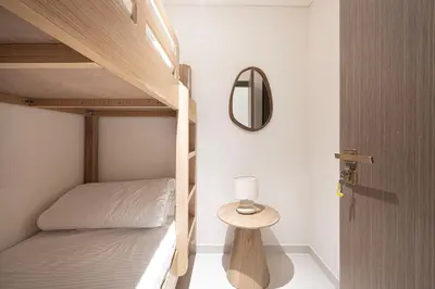 a bedroom with two bunk beds and a table with a lamp at Luxe 4BR with Panoramic Views l Marina & Burj in Dubai