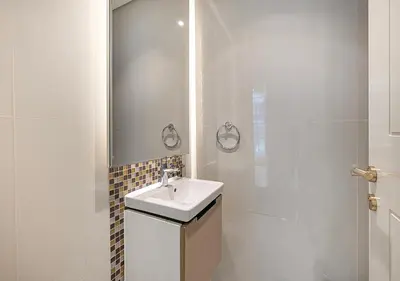 a white bathroom with a sink and a shower at Nice 2 Bedroom Apartment! 5 Minute walk to Dubai Mall! Burj Khalifa View! in Dubai