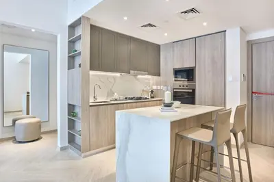 a kitchen with a island with chairs and a counter top at Stylish 1BR Retreat in JVC Modern & Cozy Stay in Dubai