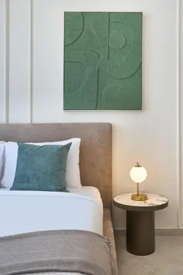a bedroom with a bed and a table with a lamp at Stylish 1BR Retreat in JVC Modern & Cozy Stay in Dubai