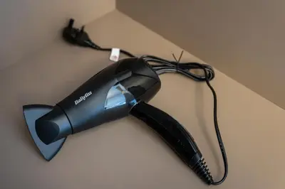 a black hair dryer sitting on a table at Luxury Meydan Studio Near Dubai Mall & Downtown in Dubai