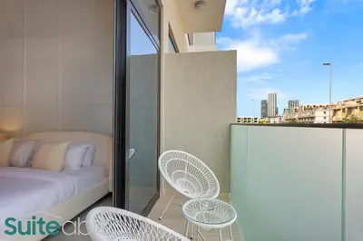 a bedroom with a bed and chairs on a balcony at Luxe Interior Studio in Pantheon Elysee 3 in JVC in Dubai